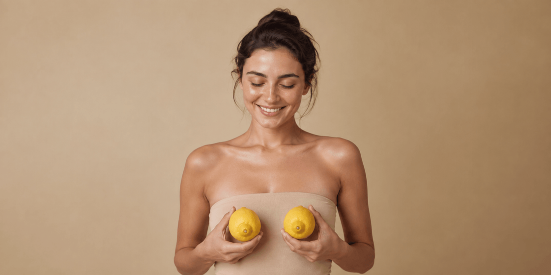 Fresh lemons beside skincare glassware in warm sunlight