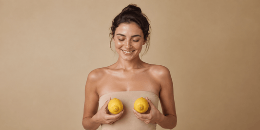 Fresh lemons beside skincare glassware in warm sunlight